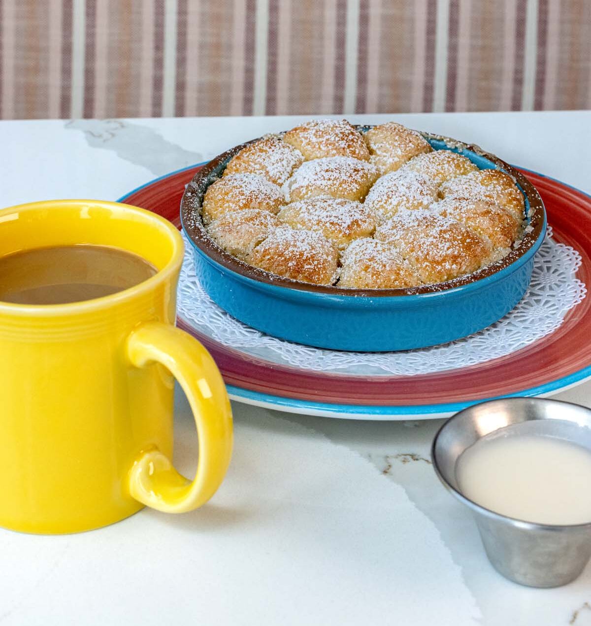 pull-apart monkey bread covered in powdered sugar, served with yellow coffee mug