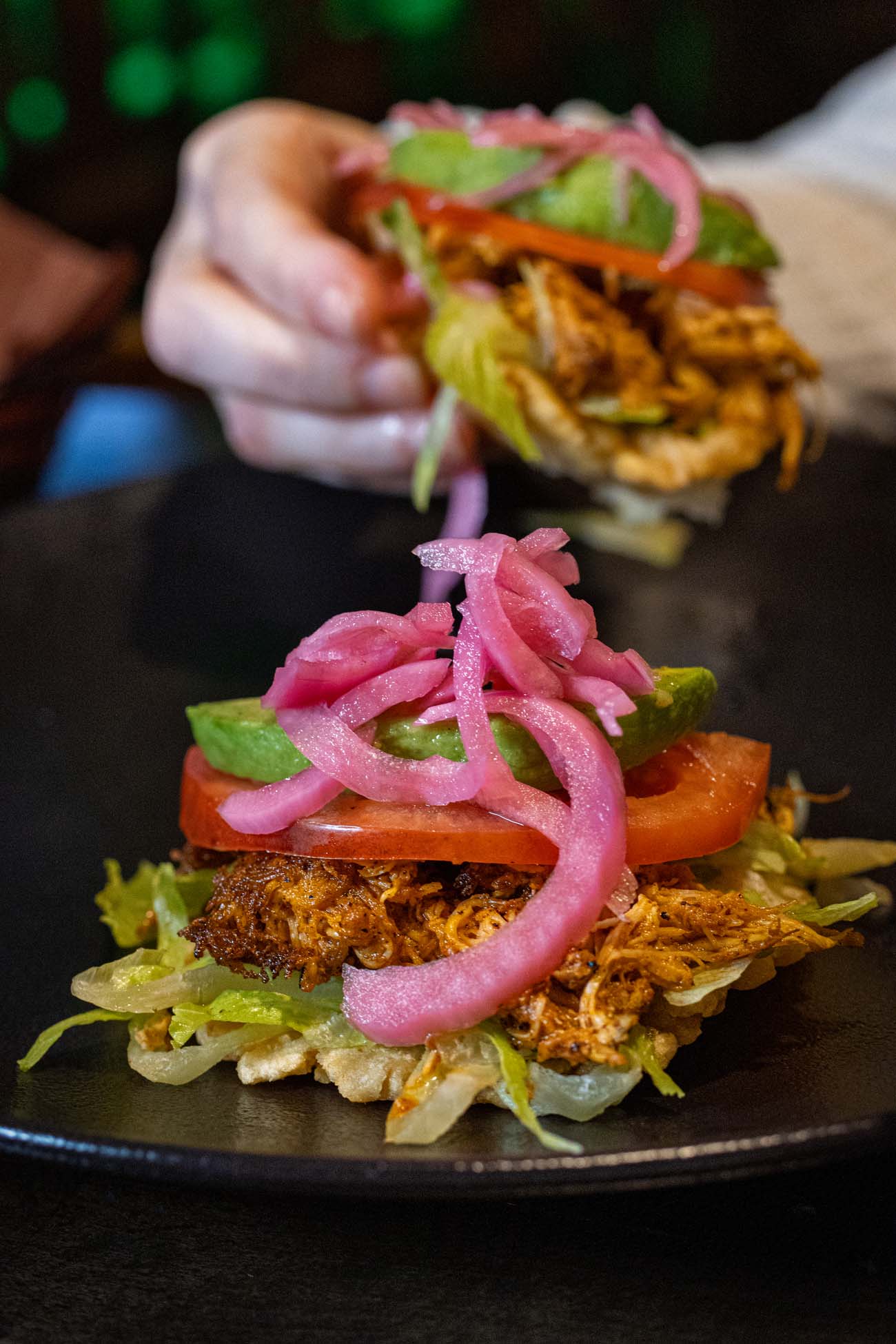 Authentic Mexican puffy chicken tacos with crispy fried handmade corn tortillas topped with shredded lettuce, grilled chicken, diced tomatoes, avocado slices and bright pink pickled onions at Felix's Cantina La Posada Milford Pennsylvania